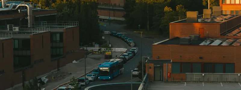 The Aalto University campus in Otaniemi at sunset, a blue bus rounding the corner between the brick buildings